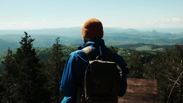 Male hiker with raised arms celebrating at the summit of Tornik mountain in Zlatibor, Serbia, under a bright blue spring sky. Solo travel concept. Horizontal 4k footage