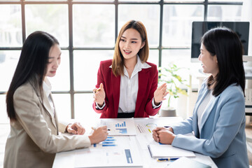 Three women are sitting at a table, discussing business matters