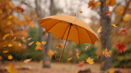 A yellow umbrella is flying through a field of falling leaves