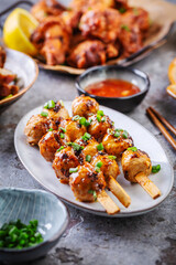 Assortment of Asian street food, stir fry with vegetables, chicken wings, meat balls and rice