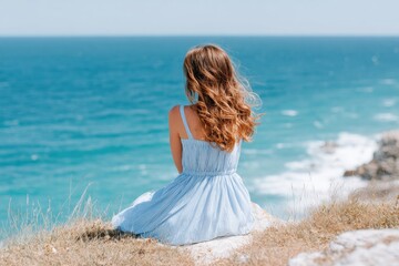 Woman relaxing and admiring ocean view from cliff