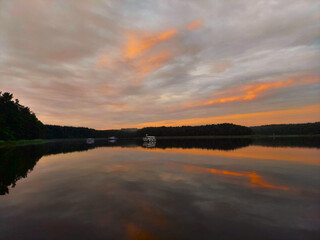 dramatic sunset over a tranquil lake with a few boats