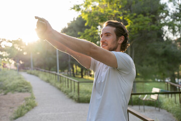 Man stretching in park during sunset
