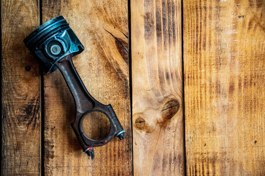 Worn Engine Piston on Rustic Wooden Surface &ndash; Industrial Still Life