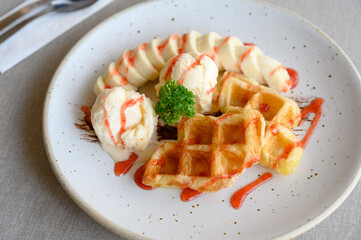 tasty dessert. Croffle serve with ice cream, banana and topping with strawberry syrup.