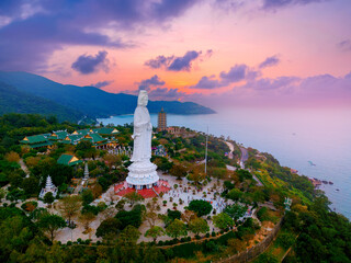 Giant lady buddha statue overlooking scenic Da nang coastline at sunset