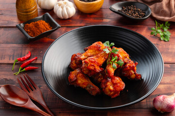 Air Fryer spicy marinated chicken drumettes in black plate.Healthy cooking low calorie.