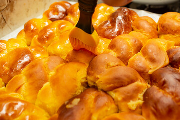 Kitchen brush smearing honey syrup on sfintisori .Romanian cuisine. Homemade Mucenici, traditional desserts made in the figure 8, smeared with honey and chopped nuts