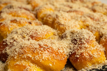 Sprinkling grated nuts on sfintisori .Romanian cuisine. Homemade Mucenici, traditional desserts made in the figure 8, smeared with honey and chopped nuts