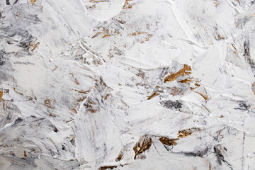 Putty white paste mixed with black ink, abstract close up detail of spatula strokes on golden paint...