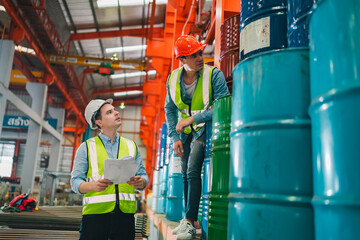 Industrial engineers inspect liquid storage drums in large-scale warehouse for export logistics, ensuring safety compliance, shipping standards, quality control of materials