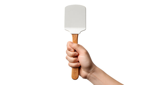 Hand holding a white spatula with wooden handle against a isolated on white transparent background depicting cooking and baking essentials 