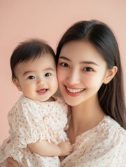 Portrait of happy Asian mom and baby bonding and smiling together. Happy family, beautiful background, mockup for motherâs day. Publicity poster, healthy happy family. Tender moments between mother