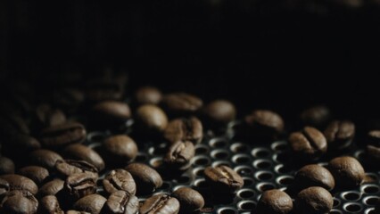 Roasted coffee beans cooling down on metal tray,