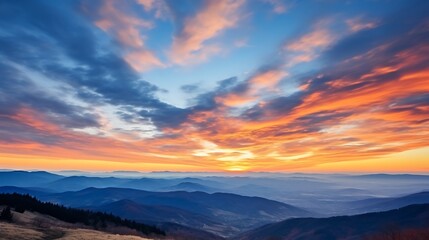 Obraz premium A vibrant sunrise sky over the Carpathian mountains, clouds swirling in shades of peach, gold, and deep blue, mountain silhouettes sharp against the brightening sky.