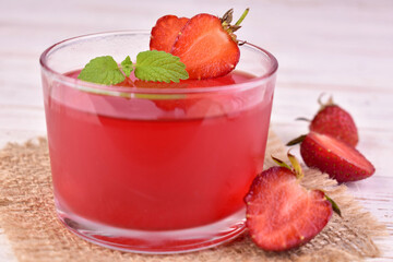 Strawberry jelly in a glass on a white background. Close-up.
