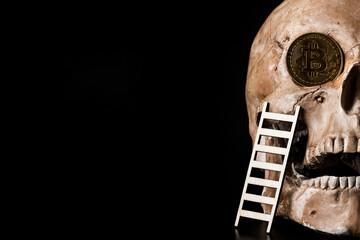 Coin with the symbol of the cryptocurrency Bitcoin in the shape of a human skull on a black background