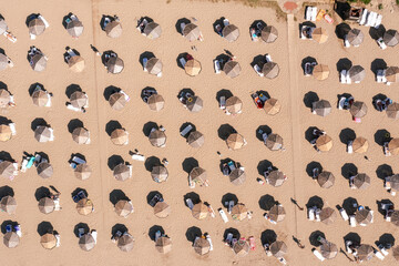 Aerial view to a sandy beach and sunshade with sunumbrellas