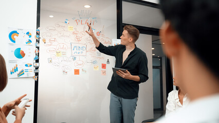 Fototapeta premium Professional male leader presents start up project by using mind map, colorful sticky notes and business statistic graph with confident while investor listening carefully. Immaculate.