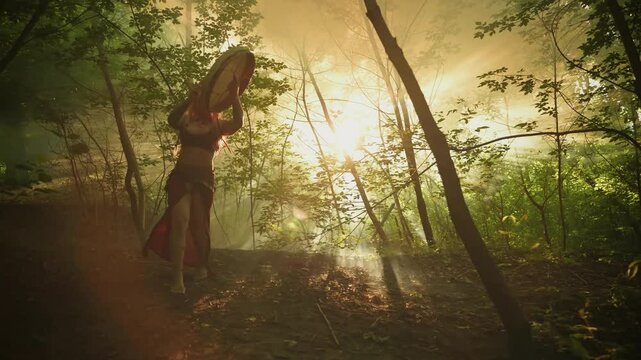 Boho shamanic woman playing on shaman frame drum, holds musical instrument in hands plays music beats trance zen mantra calm relax yoga. forest green trees. Happy Sexy Fairy Girl Viking Nordic Culture