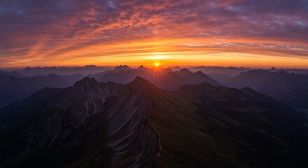 Fototapeta premium Majestic Mountain Sunset Panorama - Serene sunset over majestic mountains, symbolizing peace, adventure, nature's beauty, tranquility, and hope. A breathtaking view of fiery colors at dawn