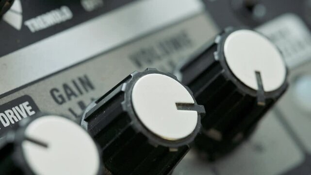 Man tuning volume and gain knobs on guitar amplifier. 4k video footage UHD 3840x2160