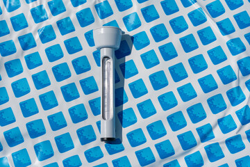 Floating thermometer for the pool on the blue floor pattern. Clear, detailed shot.