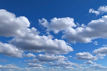 Obraz premium Fluffy white clouds dot a bright blue sky creating a serene open atmospheric scene