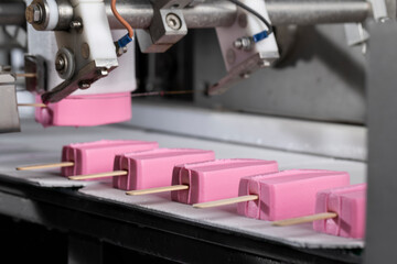 Close-Up of Pink Ice Cream Popsicles on Industrial Production Line – Frozen Dessert Manufacturing
