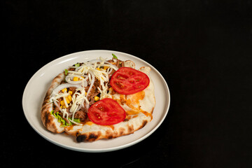 Beef sandwich with onion, lettuce, corn, tomato and cheese