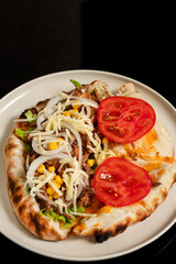 Beef sandwich with onion, lettuce, corn, tomato and cheese