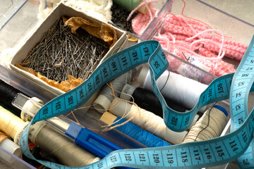 Sewing accessories and fabric. Sewing threads, needles, pins, fabric, buttons and sewing centimetr. Top view