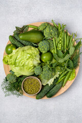Fresh green organic vegetables assorted on a plate. Healthy lifestyle, detox, flat lay.