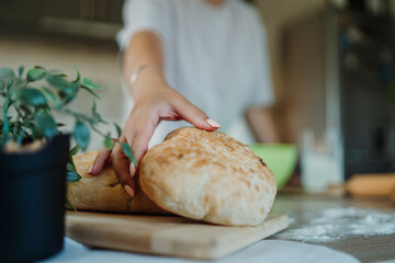 Young caucasian woman making bread dough with rolling pin and flour