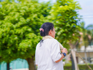 Happy senior exercise woman run in the park vacation for healthy lifestyle. Elderly care Asian female enjoy jogging using fitness tracker for wellness health in holiday. Concept digital healthcare