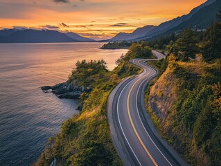 A scenic highway runs along the Pacific coast near Vancouver, Canada. The road is between the ocean and mountains. Beautiful, colorful sunset.
