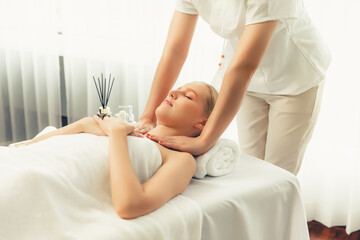 Obraz premium Caucasian woman customer enjoying relaxing anti-stress spa massage and pampering with beauty skin recreation leisure in day light ambient salon spa at luxury resort or hotel. Quiescent