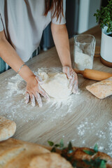 Young caucasian woman making bread dough with rolling pin and flour