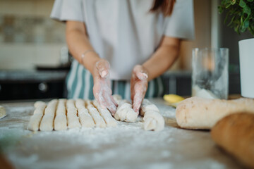 Young caucasian woman making bread dough with rolling pin and flour