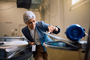 Female quality control inspector at work at food factory.