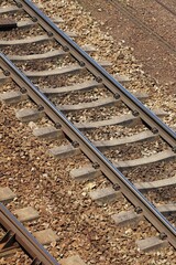Close-up of railway tracks with metal rails and wooden sleepers. Details of construction and...