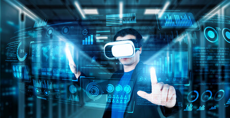 Businessman with headset standing at data center while analyzing financial data. Manager pointing marketing statistic hologram and using augmented reality goggles while making a decision. Ingenuity.