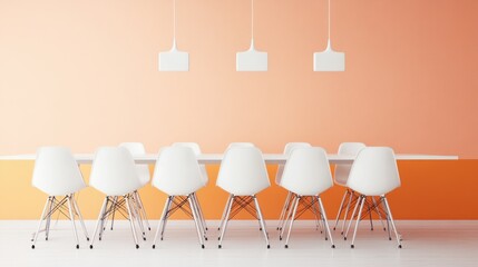 White chairs around a long white table in a room with peach and orange walls.