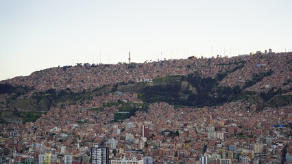 Aerial views of La Paz, Bolivia featuring the cable car system, city sprawl, and majestic snow-capped Andes mountains in the background.