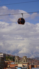 Aerial views of La Paz, Bolivia featuring the cable car system, city sprawl, and majestic snow-capped Andes mountains in the background.