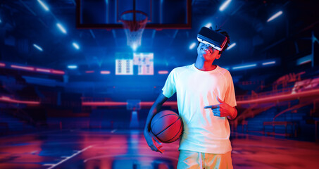 Basketball player holding basketball hologram at futuristic sport arena. Energetic athlete or sport person practicing basketball skill by using augmented reality technology. Innovation. Ingenuity.