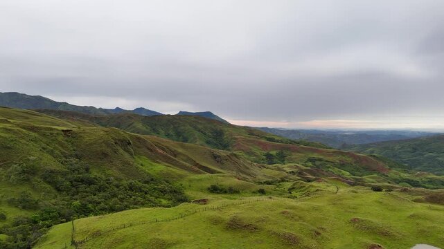 Wide aerial of rolling hills and puddles under soft evening light in the highlands of Ng&auml;be-Bugl&eacute;, Panama