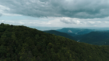 Aerial view of dense forest in Ovcar mountain. Serbia country nature under cloudy spring sky