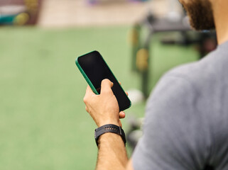 Portrait of a young black man using a phone ant exting taking a break exercising in a gym, having a training workout in gym, healthy lifestyle and cardio exercise at fitness club concepts