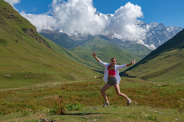 Girl jumping in the mountains in Ushguli in summer